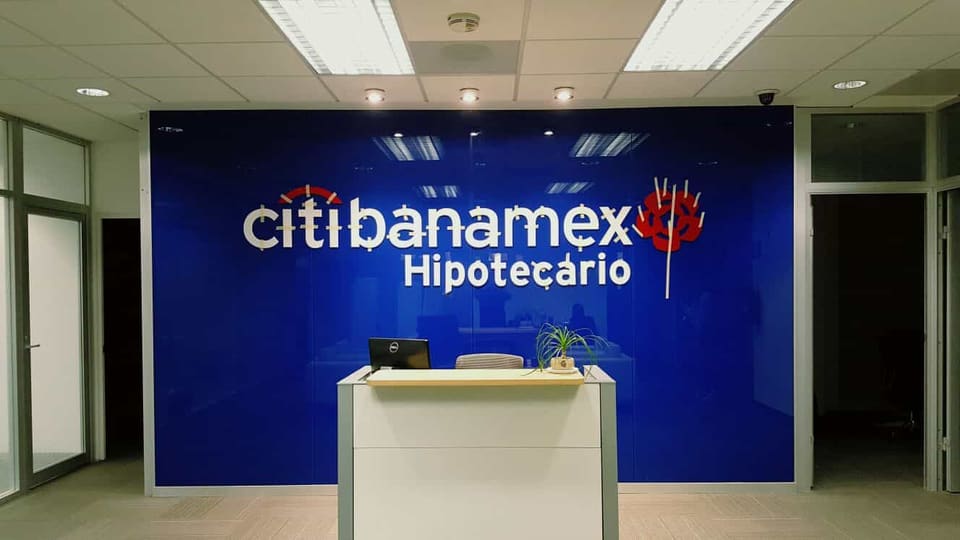 Mostrador de recepción corporativa y muro con identidad volumétrica
